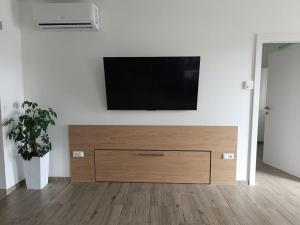 a flat screen tv on a white wall in a living room at Ferienwohnung Albel in Velden am Wörthersee
