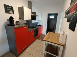 a small kitchen with red cabinets and a counter at Ferienwohnung Albel in Velden am Wörthersee