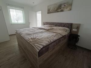 a large bed in a bedroom with a wooden floor at Ferienwohnung Albel in Velden am Wörthersee