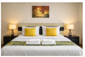 a bedroom with a large bed with two towels on it at Covenant Crest Hotel in Accra