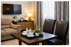 a living room with a table and chairs and a couch at Covenant Crest Hotel in Accra