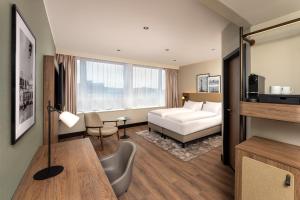 a hotel room with a bed and a table at Hotel Astor Kiel by Campanile in Kiel