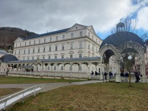 a large white building with a clock on it at Apartment Lilianna in Karlovy Vary