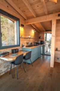 a kitchen with a table and chairs in a cabin at Cocooon Wood, hébergement insolite Savoie in Saint-Paul-sur-Yenne
