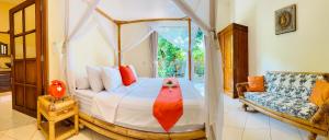 a bedroom with a canopy bed and a couch at Villa Mawar in Pengastulan