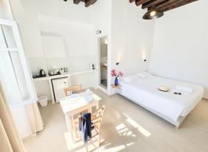 a white room with a bed and a table at Castellino Naxos in Naxos Chora