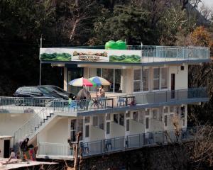 two people with umbrellas on the balcony of a building at Corn Village Retreat in Mussoorie
