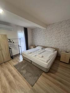 a bedroom with a white bed and a wall at Ezüst Mező Vendégház in Nagyecsed +20 photos