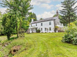 a large white house with a grassy yard at 4 Bed in Tavistock oc-92491 in Bulkworthy