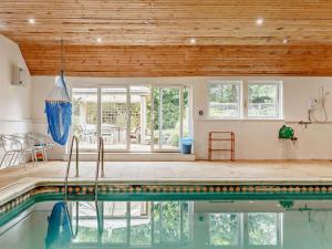a swimming pool in a house with a wooden ceiling at 4 Bed in Tavistock oc-92491 in Bulkworthy