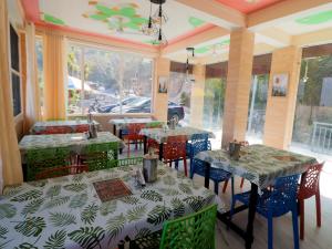 a restaurant with tables and chairs in a room at Corn Village Retreat in Mussoorie