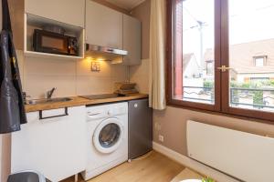 a kitchen with a washing machine and a window at Studio à Champigny sur marne in Champigny-sur-Marne