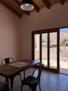 a dining room with a table and chairs and a window at Cabana Mirador Sumajpacha in Tilcara