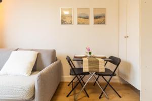 a small table and chairs in a room with a couch at Studio à Champigny sur marne in Champigny-sur-Marne