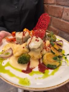 a plate of food with vegetables on a table at Zakarczmie Browar Wiejski in Leżajsk
