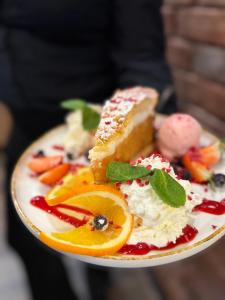 a plate of food with fruit and whipped cream at Zakarczmie Browar Wiejski in Leżajsk