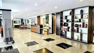 a lobby with a room with a table and shelves at Dynasty Grande Hotel in Bangkok