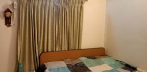 a bedroom with a bed and a window with curtains at Nalukettu Veedu in Thottada