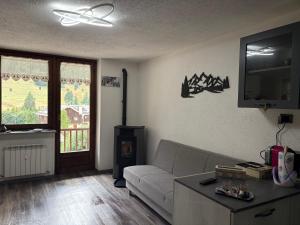 a living room with a couch and a tv at Appartamento G&G in Pontechianale