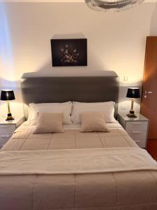 a bedroom with a large white bed with two lamps at Pool Apartment Bellagio in Bellagio +20 photos