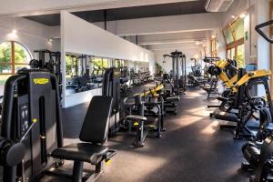 a gym with rows of treadmills and machines at Villa Greif Apartment in Lignano Sabbiadoro
