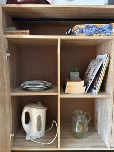 a wooden book shelf with plates and a tea pot at Florija’s Guesthouse in Dardhë +13 photos