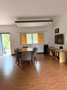 a living room with a table and chairs and a television at Casa Olivia in Puerto Galera
