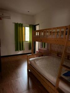 a bedroom with two bunk beds and green curtains at Casa Olivia in Puerto Galera