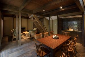 a dining room with a wooden table and chairs at Choya Goshominami Machiya House in Kyoto