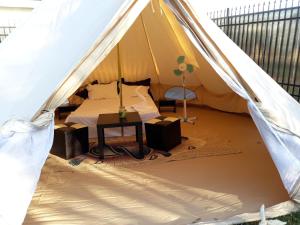a tent with a bed and a table in it at Aurora Glamping in Vama Veche