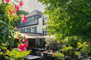a restaurant with tables and flowers in front of a building at Clostermanns Hof in Niederkassel