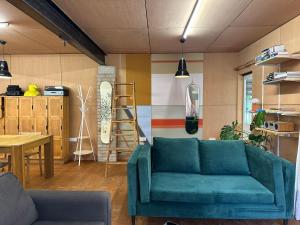 a living room with a blue couch and a table at Woodside Studio in Hassocks