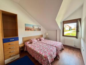 a bedroom with a bed and a dresser and a window at Villa de Pedrena - 32801 in Pedreña