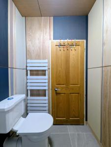 a bathroom with a toilet and a wooden door at Woodside Studio in Hassocks +31 photos