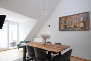 a dining room with a wooden table and chairs at Design Apartments - "Potsdam City" , 19 in Potsdam +13 photos