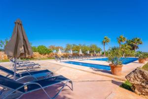 a swimming pool with chairs and an umbrella at Agroturismo Mondrago -Antic Na Martina- in Portopetro +121 photos