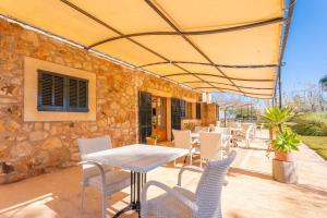 a table and chairs under an umbrella on a patio at Agroturismo Mondrago -Antic Na Martina- in Portopetro