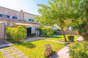 a garden with a table and a tree and a building at Agroturismo Mondrago -Antic Na Martina- in Portopetro