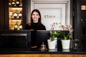 a woman sitting at a counter in a coffee shop at Hotel Fabian in Helsinki