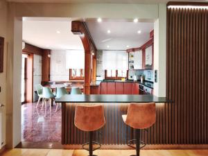 a kitchen with a bar and some chairs in it at Casa Migjorn in Valls de Torroella +25 photos