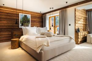 a bedroom with a large bed with a wooden wall at Flora Boutique Hotel in Borovets +129 photos