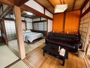 a room with a couch and a bed and a table at おやど 瀬名 in Tanabe
