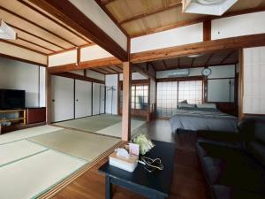 a large room with a bed and a couch at おやど 瀬名 in Tanabe