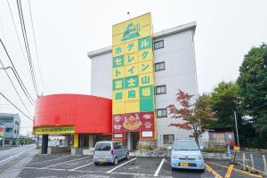 Select Inn Fujisan Gotemba في غوتيمبا: مبنى فيه سيارات متوقفة في موقف للسيارات
