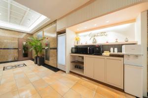 a kitchen with black appliances in a room at Dongdaemun Signature Tourist Hotel in Seoul