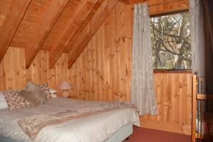 a bedroom with a bed and a window in a cabin at Snowdrop Lodge in Dinner Plain
