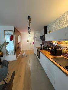 a kitchen with white cabinets and a counter top at Escale Cosy à Villeneuve in Villeneuve-la-Garenne