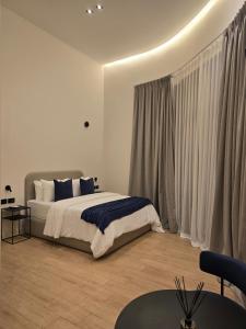 a bedroom with a bed and a table and curtains at Hotel Boutique Ubuntu in Buenos Aires