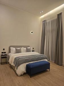 a bedroom with a large bed and a blue ottoman at Hotel Boutique Ubuntu in Buenos Aires