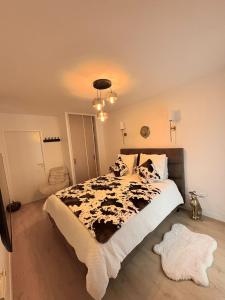 a bedroom with a bed with a black and white comforter at Escale Cosy à Villeneuve in Villeneuve-la-Garenne +33 photos